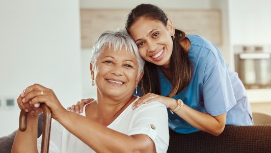 Smiling senior woman at home with her caregiver